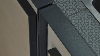 Détail d'agencement : cadre en acier noir et panneaux de bouleau